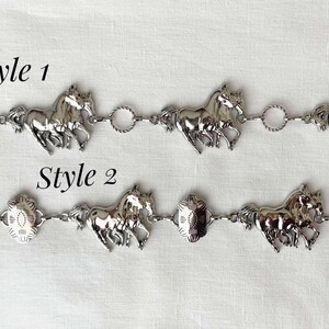 May include: Two silver-toned horse-themed belts. Style 1 features running horse charms connected by circular links. Style 2 has horse charms and decorative centerpieces. The text "Style 1" and "Style 2" are visible.
