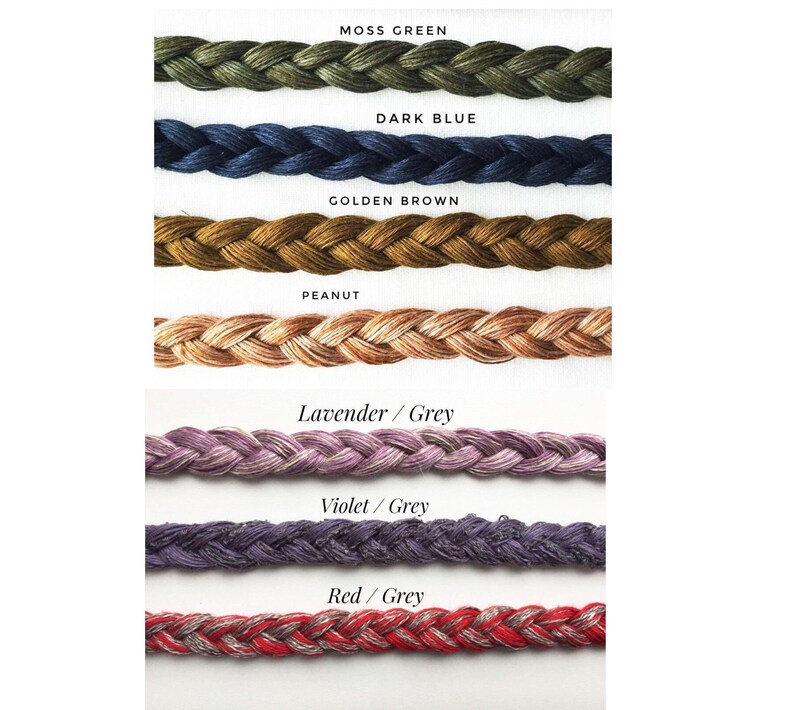 Peut inclure: Gros plan sur dix couleurs diff&eacute;rentes de cordon tress&eacute;. Les couleurs sont vert mousse, bleu fonc&eacute;, brun dor&eacute;, cacahu&egrave;te, lavande/gris, violet/gris et rouge/gris.