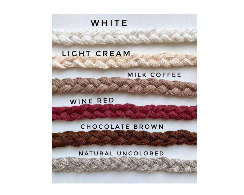 Peut inclure: Gros plan sur six cordes tress&eacute;es de couleurs diff&eacute;rentes. Les couleurs sont blanc, cr&egrave;me clair, caf&eacute; au lait, rouge vin, brun chocolat et naturel non color&eacute;.