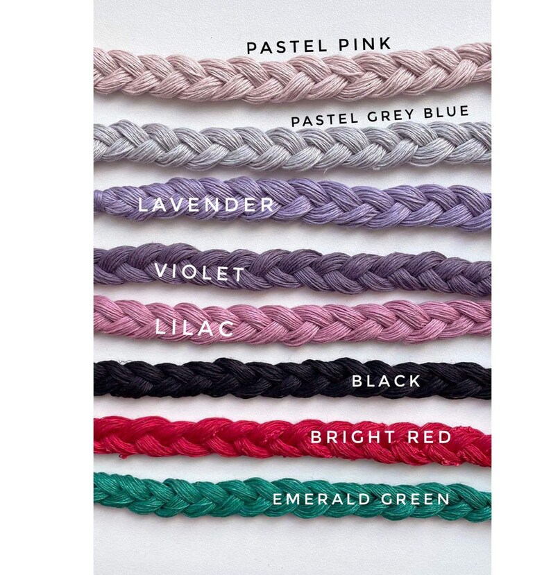 Peut inclure: Gros plan sur huit couleurs diff&eacute;rentes de cordon tress&eacute;, dont rose pastel, bleu gris pastel, lavande, violet, lilas, noir, rouge vif et vert &eacute;meraude.