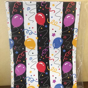 May include: A sheet of white wrapping paper with black stripes and a repeating pattern of colorful balloons, confetti, and curly ribbons.