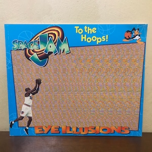 Pode incluir: Um livro azul e laranja do Space Jam com o texto "To the Hoops!" e "Eye Illusions" na capa. O livro apresenta uma imagem de desenho animado do Bugs Bunny jogando basquete.
