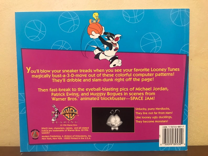 Pode incluir: Uma capa de livro com o Pernalonga e o Piu-Piu jogando basquete. A capa &eacute; azul e rosa com o t&iacute;tulo "Space Jam" e o texto "Voc&ecirc; vai estragar seus t&ecirc;nis quando vir seus Looney Tunes favoritos saindo desses padr&otilde;es coloridos de computador em 3D! Eles v&atilde;o driblar e enterrar direto da p&aacute;gina!"
