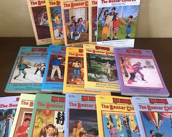 Puede incluir: Una colección de libros antiguos de "The Boxcar Children". Las portadas presentan ilustraciones coloridas de niños en varios escenarios, incluyendo una escena de nieve, un desierto y un parque de bomberos. Los títulos están impresos en negrita roja.