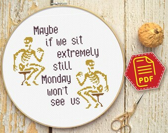 May include: Cross stitch pattern featuring two skeletons sitting on chairs with the text "Maybe if we sit extremely still Monday won't see us".
