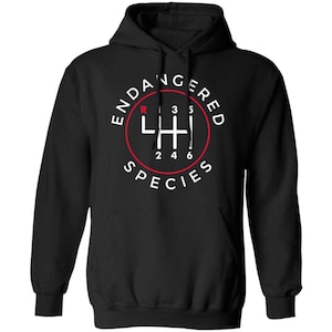 May include: Black hooded sweatshirt with a white and red graphic. The graphic features a gear shift pattern inside a red circle, with the words "ENDANGERED SPECIES" in white text around the circle.
