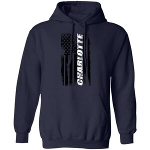 May include: Navy blue hooded sweatshirt with a distressed American flag design and the word "CHARLOTTE" in white lettering.