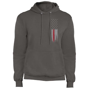 May include: A charcoal gray hooded sweatshirt with a distressed American flag design featuring a red stripe. The flag is on the left chest of the sweatshirt.