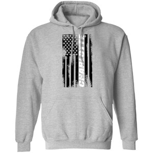May include: A gray hooded sweatshirt with a black and white American flag design. The word "CHARLOTTE" is written vertically in white on the flag.