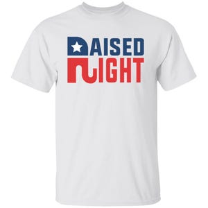 May include: A white short-sleeved t-shirt featuring the text RAISED RIGHT printed on the chest. The word RAISED is in dark blue with a white star inside the letter R, and the word RIGHT is in red with a stylized letter R.