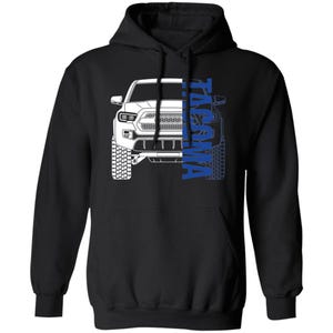 May include: Black hoodie with a white outline of a Toyota Tacoma truck and the word "Tacoma" in blue lettering.