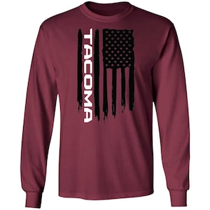 May include: A maroon long-sleeve t-shirt with a black and white American flag design and the word "TACOMA" in white lettering.
