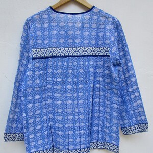 May include: A blue and white cotton tunic top with a floral print and a blue trim around the neckline and hem.