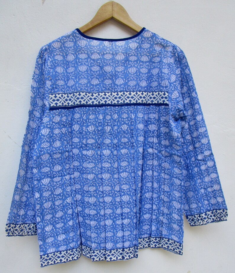 May include: A blue and white cotton tunic top with a floral print and a blue trim around the neckline and hem.