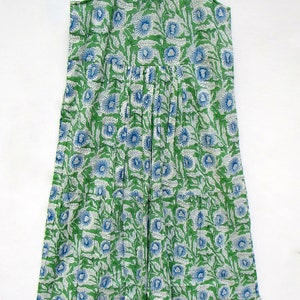 May include: A green and blue floral print sleeveless dress with a ruffled hem.