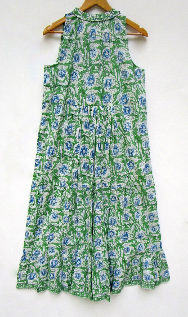 May include: A green and blue floral print sleeveless dress with a ruffled hem.