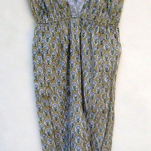 May include: A sleeveless, loose-fitting dress with a V-neckline and a floral print in shades of green, white, and brown.