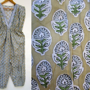 May include: A beige cotton jumpsuit with a V-neck and a floral print in shades of blue and green.