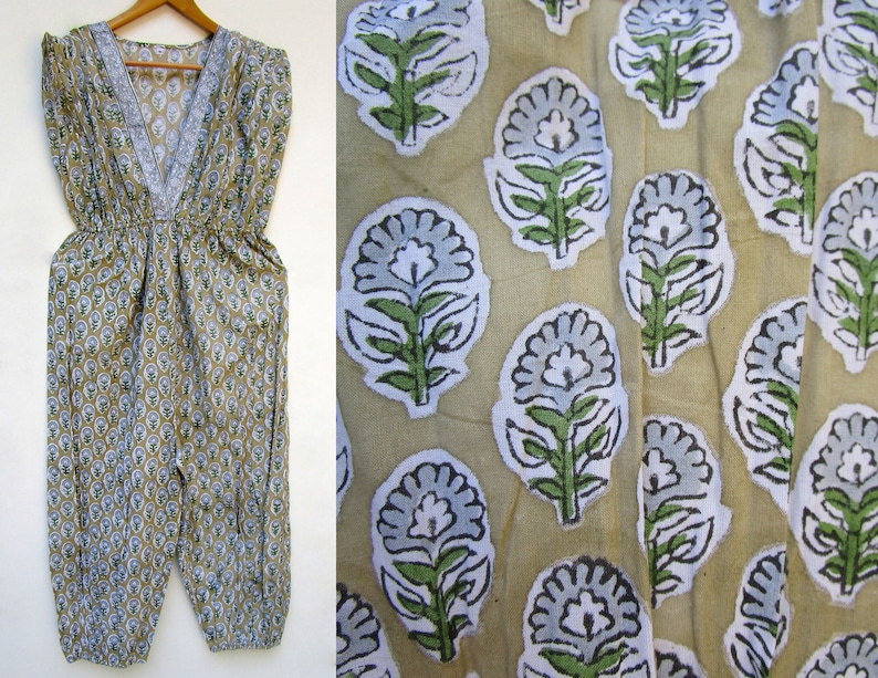 May include: A beige cotton jumpsuit with a V-neck and a floral print in shades of blue and green.
