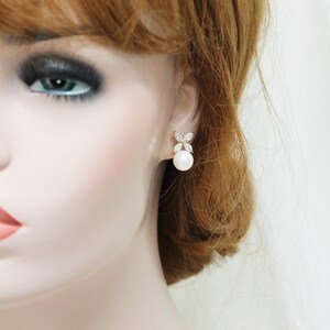 Puede incluir: Pendientes de oro con una perla y detalles de cristal transparente. Los pendientes tienen un dise&ntilde;o simple y elegante.