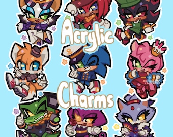 May include: A collection of colorful acrylic charms featuring various characters from the Sonic the Hedgehog franchise. The charms include Sonic, Tails, Knuckles, Shadow, Amy, Rouge, Vector, and Wave. The text "Acrylic Charms" is displayed in the center.