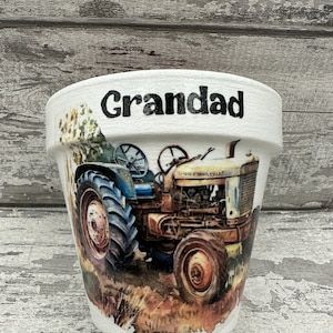 May include: White ceramic planter with a tractor design and the word "Grandad" written on the side.