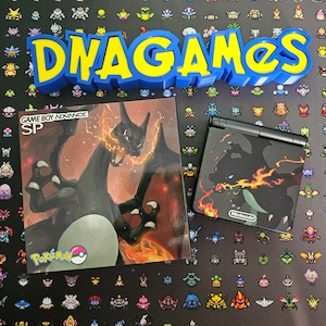 Könnte beinhalten: Eine Game Boy Advance SP Konsole mit einer schwarzen und roten Pokemon-Spielkassette, die ein feuriges Bild des Pokemon-Charakters "Groudon" zeigt. Die Konsole befindet sich auf einem schwarzen Hintergrund mit einem bunten Muster von Pokemon-Charakteren.