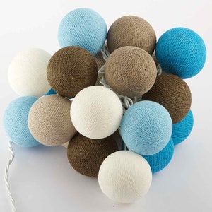 Può includere: Una stringa di luci con palline di cotone decorative in vari colori, tra cui bianco, azzurro, marrone e turchese. Le palline rotonde sono raggruppate su un filo bianco, creando una luce soffusa e calda. Ideale per la decorazione domestica.