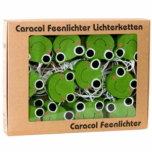 Könnte beinhalten: Eine Schachtel mit grünen, froschförmigen Lichterketten mit dem Text "Caracol Feenlichter Lichterketten" und "Caracol Feenlichter" auf der Schachtel.