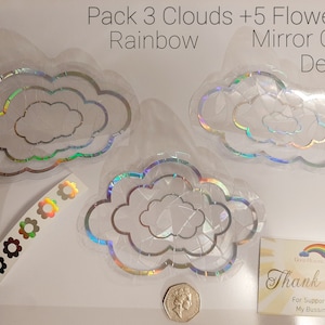 May include: A pack of 3 iridescent rainbow cloud and 5 flower mirror car decals. The decals are on a white background with a thank you note and a coin.