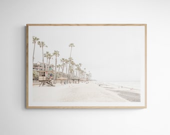 May include: A framed photograph of a beach scene with palm trees, a lifeguard stand, and people in the distance. The sand is white and the water is blue.