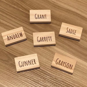 May include: Six wooden blocks with names engraved on them: Andrew, Grant, Garrett, Sadie, Gunner, and Grayson.