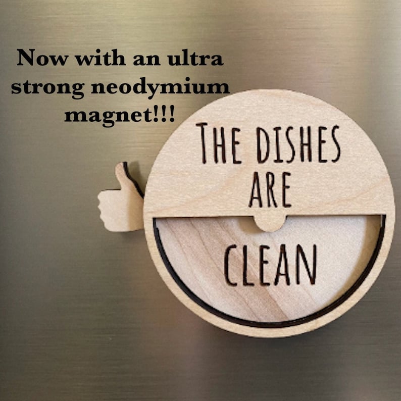 May include: A wooden sign with a thumbs up icon and the text "The Dishes Are Clean". The sign is attached to a refrigerator with a strong magnet.