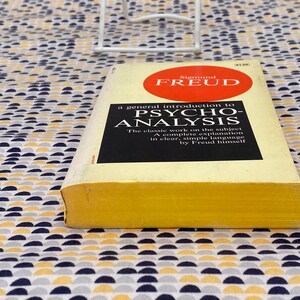 May include: A yellow paperback book with a red circle on the cover. The book is titled "A general introduction to Psycho-Analysis" by Sigmund Freud.