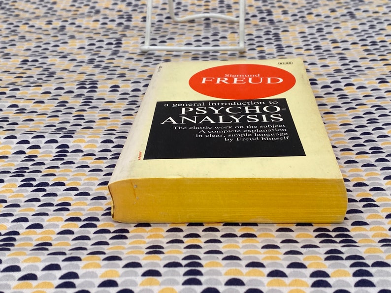 May include: A yellow paperback book with a red circle on the cover. The book is titled "A general introduction to Psycho-Analysis" by Sigmund Freud.