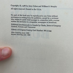 May include: Copyright information for a book published in 1966 by Jerry Cohen and William S. Murphy. The text states that all rights are reserved and the book was printed in the U.S.A. It also includes details about reproduction rights, publication details, and the Library of Congress Catalog Card Number: 66-21295. The text mentions the first and second printing dates: June 1966 and July 1966.