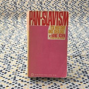 May include: A vintage book titled "PAN-SLAVISM" with a pink cover and red lettering. The book's subtitle reads "ITS HISTORY AND IDEOLOGY" by Hans Kohn. The book is a second edition and part of the Vintage Russian Library.