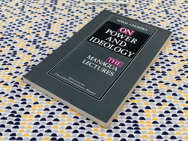 Op de afbeelding: Een grijs boek getiteld "On Power and Ideology: The Managua Lectures" van Noam Chomsky. Het boek werd gegeven aan de Universidad Centroamericano, Managua.