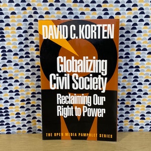 May include: A brown and black book with the title "Globalizing Civil Society: Reclaiming Our Right to Power" by David C. Korten. The book is part of the Open Media Pamphlet Series.