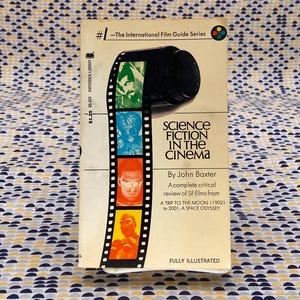 May include: A white book with a black and white filmstrip on the cover. The book is titled "Science Fiction in the Cinema" by John Baxter. The book is part of "The International Film Guide Series".