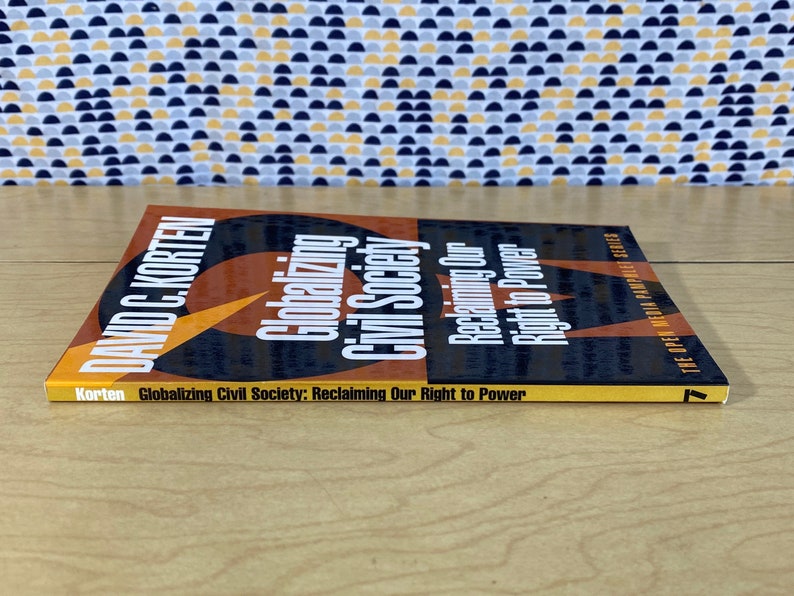 May include: A yellow, orange, and black book titled "Globalizing Civil Society: Reclaiming Our Right to Power" by David C. Korten. The book is part of the Open Media Pamphlet Series.