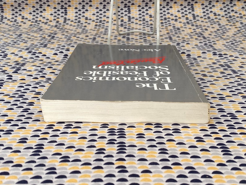 May include: A gray hardcover book titled "The Economics of Feasible Socialism" by Alec Nove.
