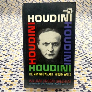 May include: A vintage paperback book titled "HOUDINI" with a portrait of the magician on the cover. The title is in white, red, and blue lettering. The book's author is William Lindsay Gresham.