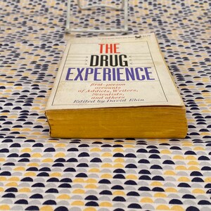 May include: A yellow and white book titled "The Drug Experience: First-person accounts of Addicts, Writers, Scientists, and others. Edited by David Ebin."