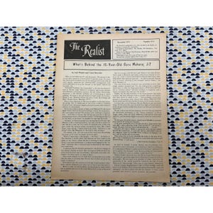 Puede incluir: Una copia vintage de la revista "The Realist" de diciembre de 1975, con el titular "What's Behind the 15-Year-Old Guru Maharaj Ji?". La revista está sobre un fondo estampado con formas azules, amarillas y blancas.