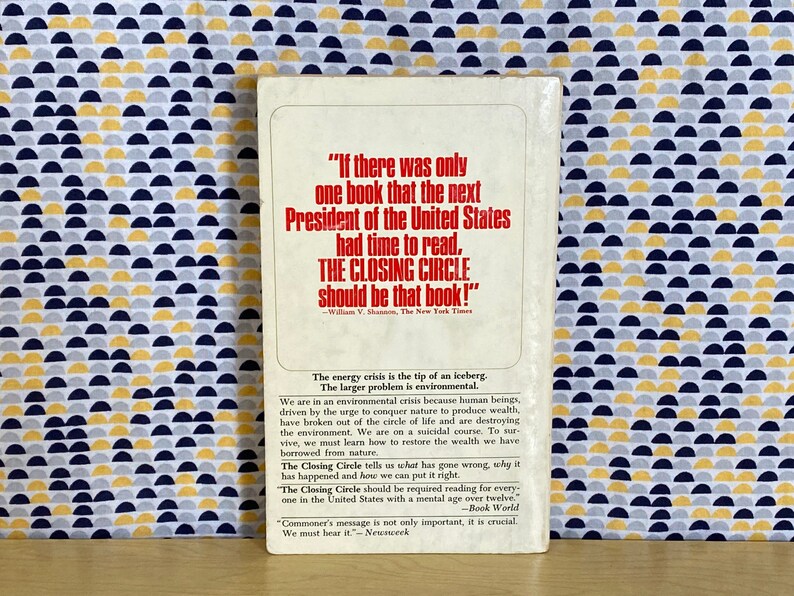 K&ouml;nnte beinhalten: Der hintere Umschlag eines Buches mit dem Titel "The Closing Circle" von Barry Commoner. Der Umschlag enth&auml;lt ein Zitat von William V. Shannon, The New York Times, der sagt: "Wenn es nur ein Buch g&auml;be, das der n&auml;chste Pr&auml;sident der Vereinigten Staaten lesen k&ouml;nnte, dann sollte es THE CLOSING CIRCLE sein!" Der Umschlag enth&auml;lt auch eine Zusammenfassung des Buchinhalts, die die Umweltkrise und die Notwendigkeit hervorhebt, den Reichtum wiederherzustellen, den wir der Natur entnommen haben.