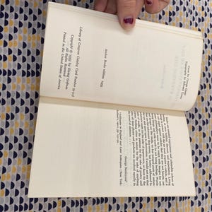 Puede incluir: Un libro abierto con texto, sostenido por una persona. Las p&aacute;ginas del libro son de color blanquecino, con texto negro. La portada no es visible. El libro es una edici&oacute;n de Anchor Books de 1959, con un n&uacute;mero de tarjeta de cat&aacute;logo de la Biblioteca del Congreso.