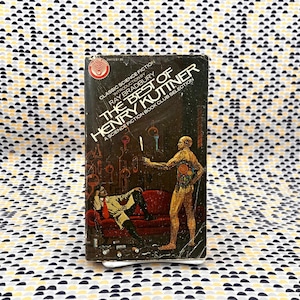 Op de afbeelding: Een vintage paperback boek getiteld "The Best of Henry Kuttner" met een sciencefiction thema. De cover toont twee figuren, een liggend op een rode bank en de andere staand, tegen een donkere achtergrond. Het boek is een Science Fiction Book Club selectie.