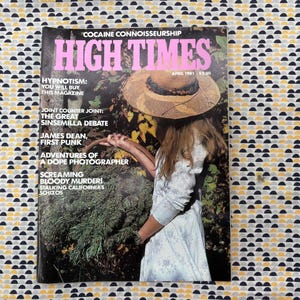Puede incluir: Una revista High Times de abril de 1981. La portada muestra a una mujer con un sombrero de paja y una cesta de vegetación. El título de la revista está en letras rosas grandes. La portada también incluye texto sobre el contenido de la revista.