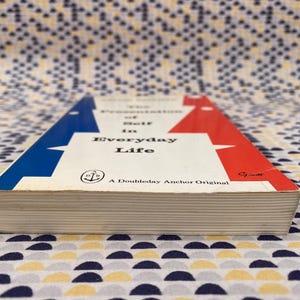 Puede incluir: Un libro vintage titulado "The Presentation of Self in Everyday Life". La portada tiene un fondo blanco con detalles en azul y rojo. Es un Doubleday Anchor Original.
